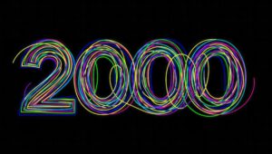 Neon rainbow loops form the number 2020 on a black background, festive and vibrant.