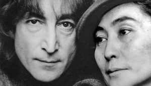 Close-up black-and-white portrait of a man and a woman looking off to the side.