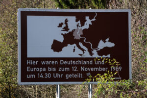 Signboard with a map of Europe and a white dividing line; German text notes the division of Germany and Europe up to 1989 (Nov 12).
