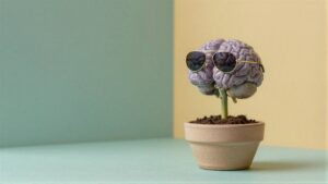 Purple brain wearing gold-ramed sunglasses perched on a plant stem in a pot against a two-tone teal and yellow backdrop