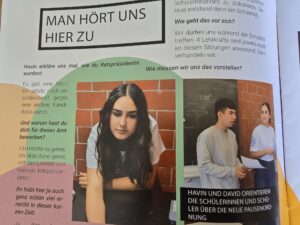 Group of students in a classroom having a discussion, with a bold header reading 'MAN HÖRT UNS HIER ZU' at the top left of the page.