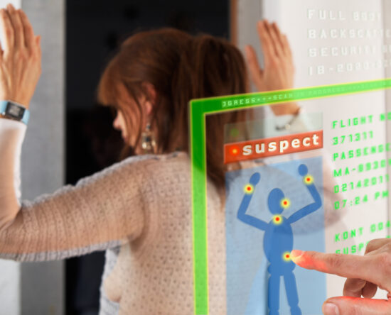 Person raises hands at a security screening console with a green progress bar and a red 'suspect' label visible on the display.