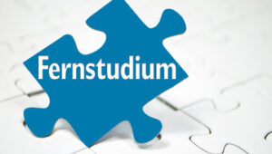 Blue puzzle piece labeled 'Fernstudium' resting on a white jigsaw background, symbolizing distance learning.